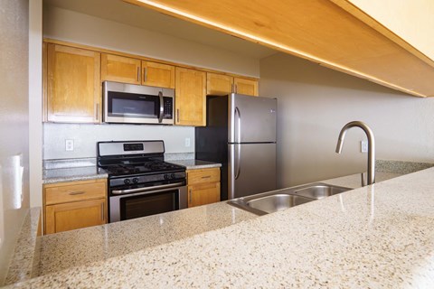 a kitchen with granite counter tops and stainless steel appliances