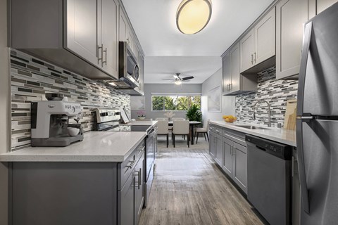 A modern kitchen with a dining table and chairs in the middle.