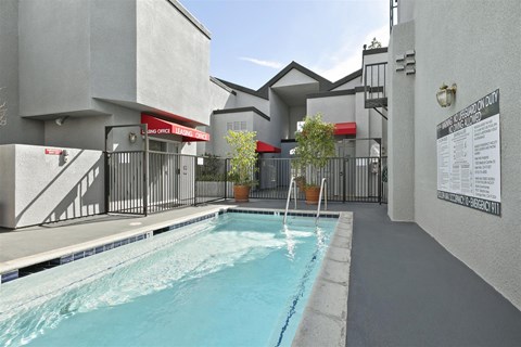 A pool in a residential area with a sign on the wall.