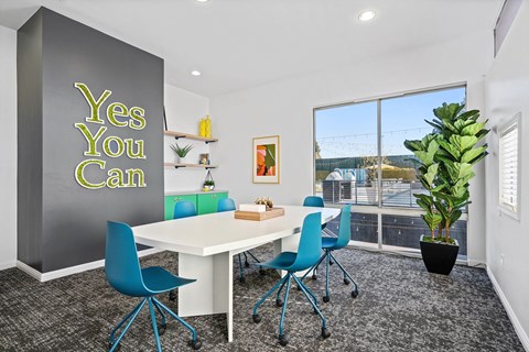 A conference room with a white table and blue chairs.