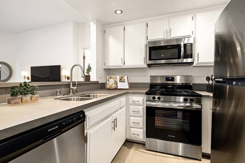 A modern kitchen with stainless steel appliances and white cabinets.