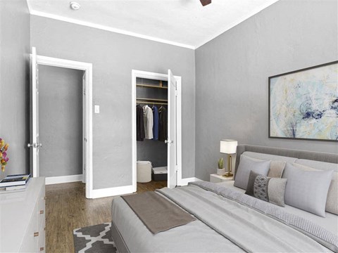 A bedroom with a bed, a nightstand, a dresser, and a painting on the wall.
