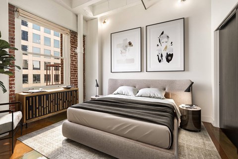 A bedroom with a large bed and two framed pictures on the wall.