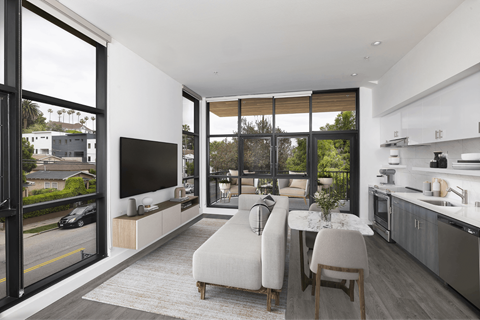 A modern living room with a large window and a flat screen TV.