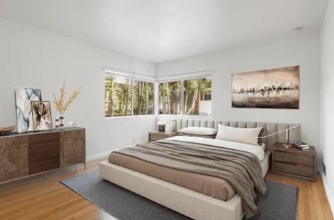 A bedroom with a large bed and a painting on the wall.