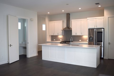 A modern kitchen with white cabinets and a large island.