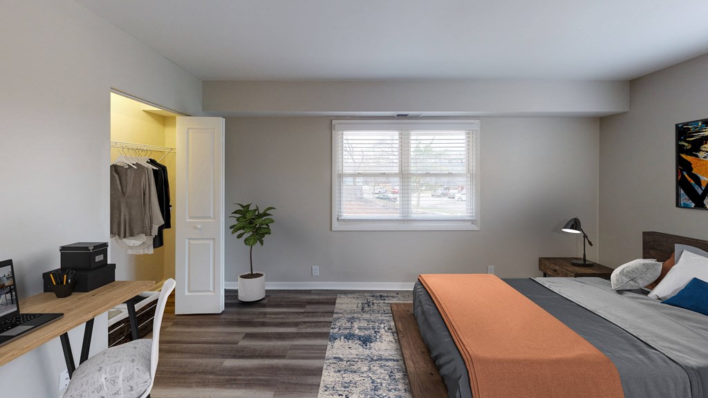 a bedroom with a bed and a desk and a window