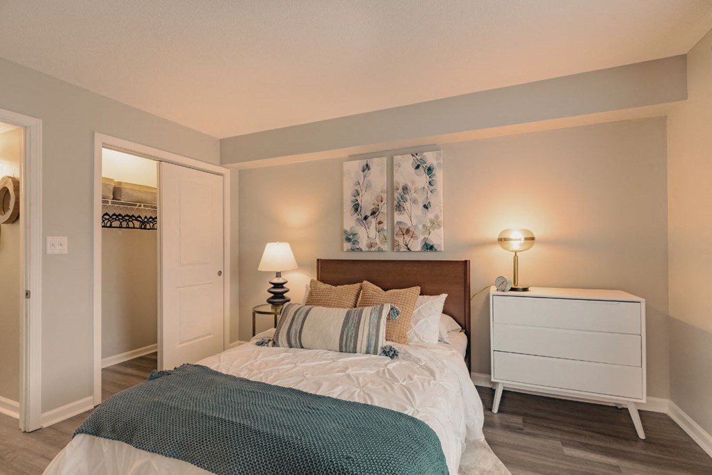 a bedroom with a bed and a nightstand with a lamp on it