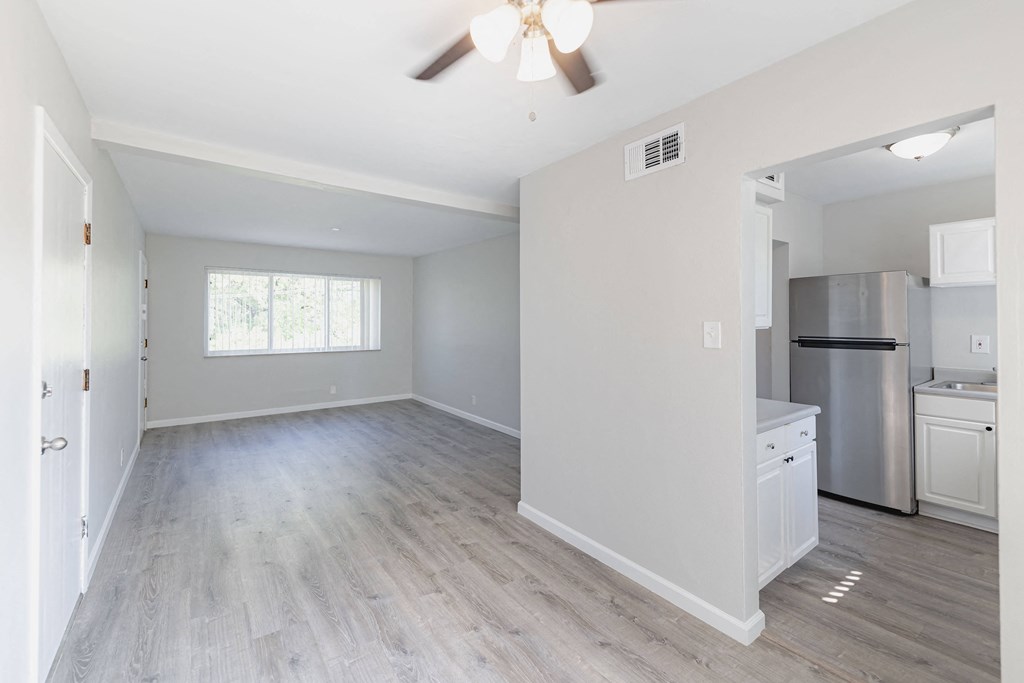 an empty kitchen and living room with a ceiling fan