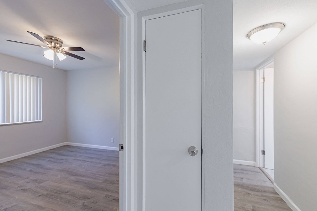 an empty bedroom with a ceiling fan and a closet