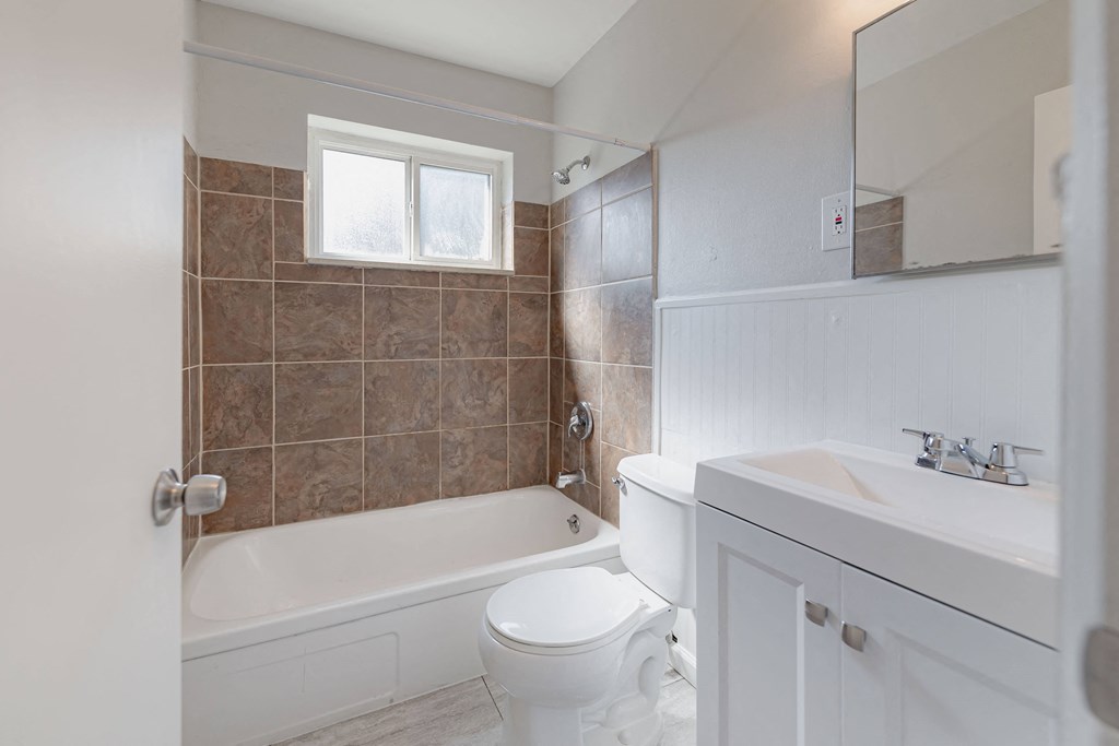 a bathroom with a toilet and a tub and a sink