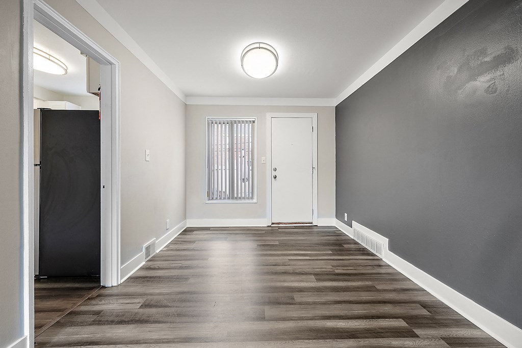 a bedroom with hardwood floors and grey walls