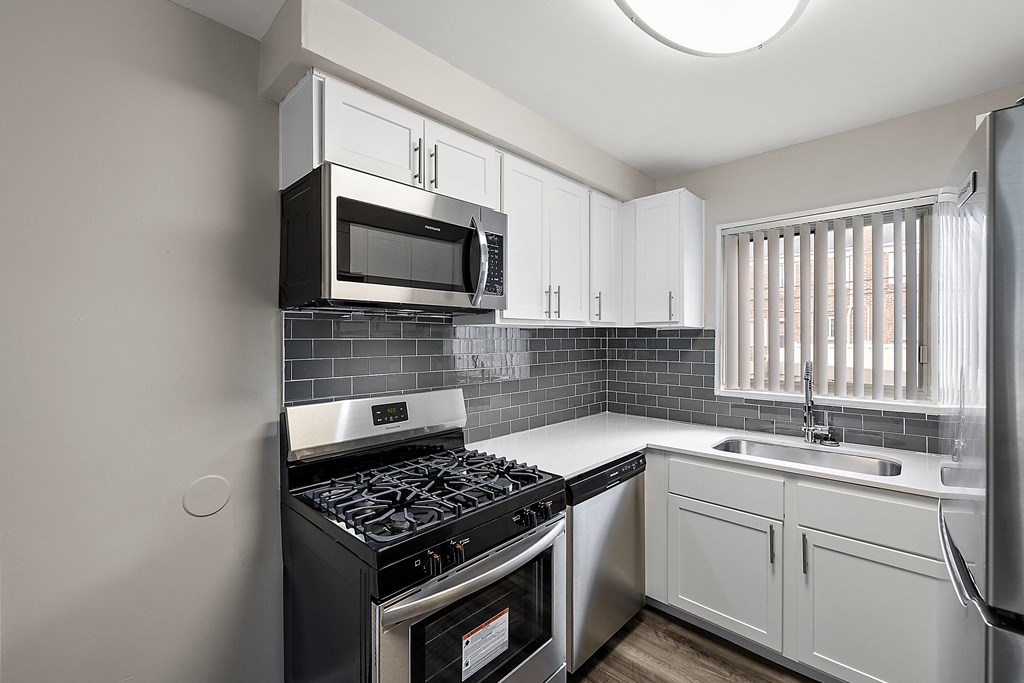 a kitchen with white cabinets and a black stove top oven