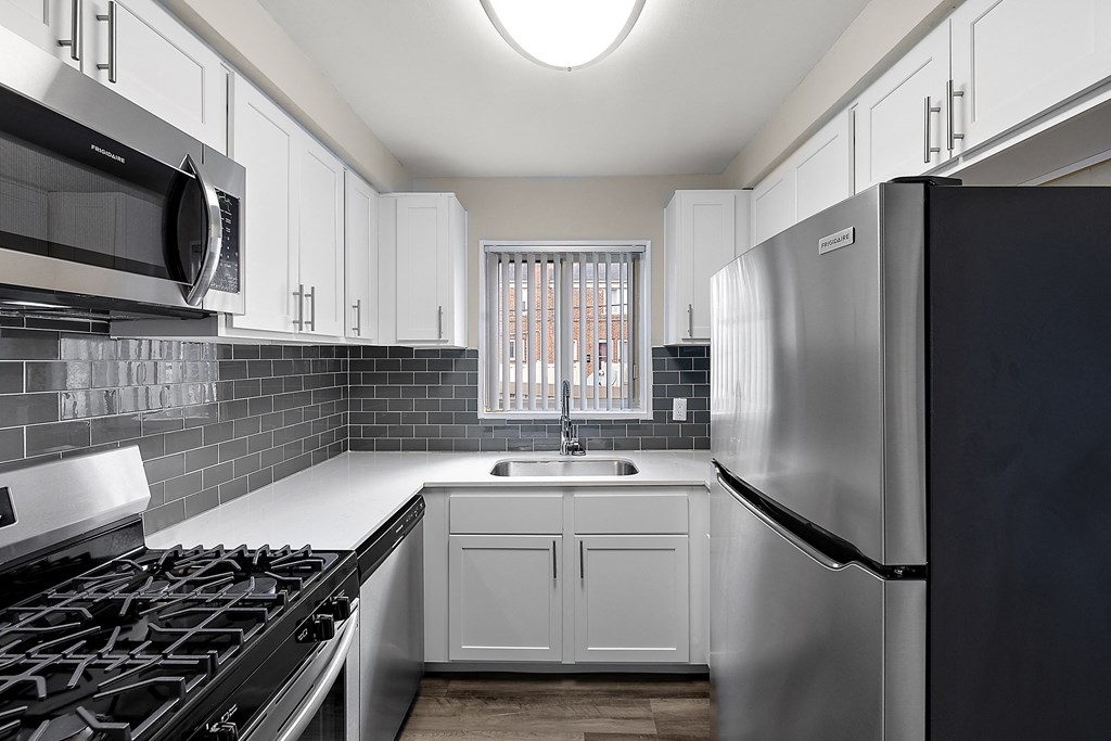 a kitchen with white cabinets and stainless steel appliances
