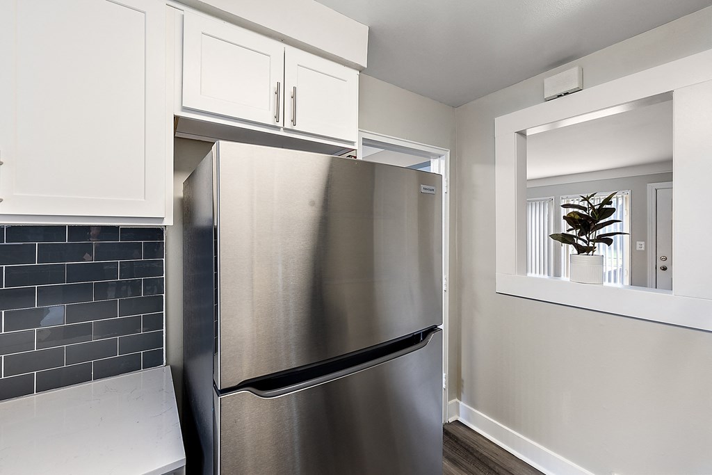 a kitchen with white cabinets and a stainless steel refrigerator