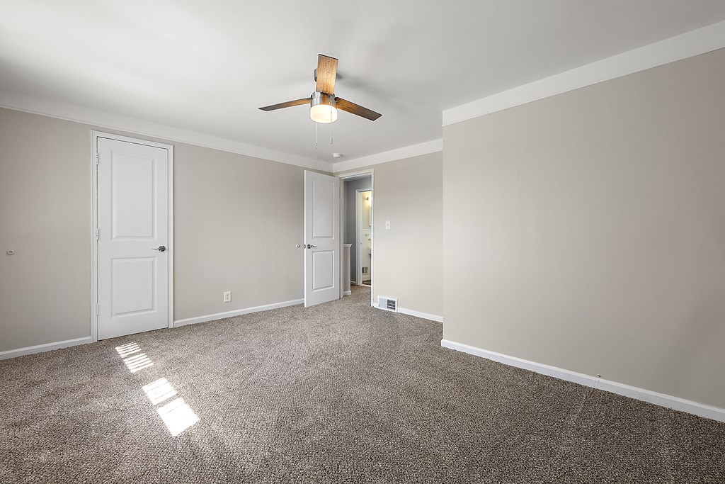 a bedroom with gray walls and a ceiling fan