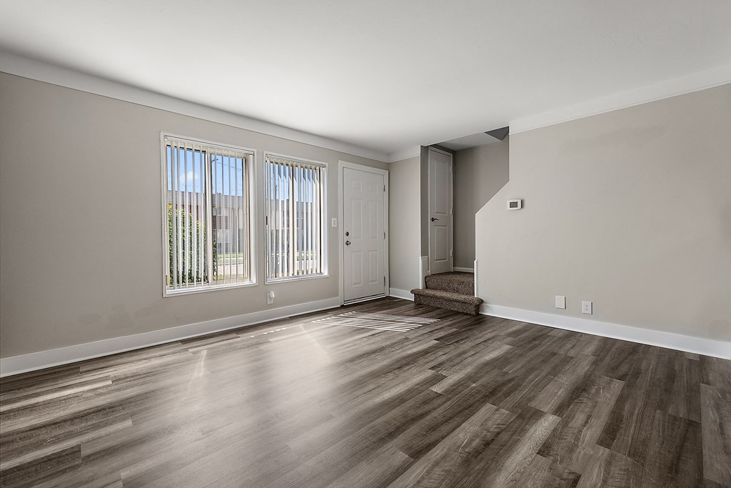 a bedroom with hardwood floors and grey walls
