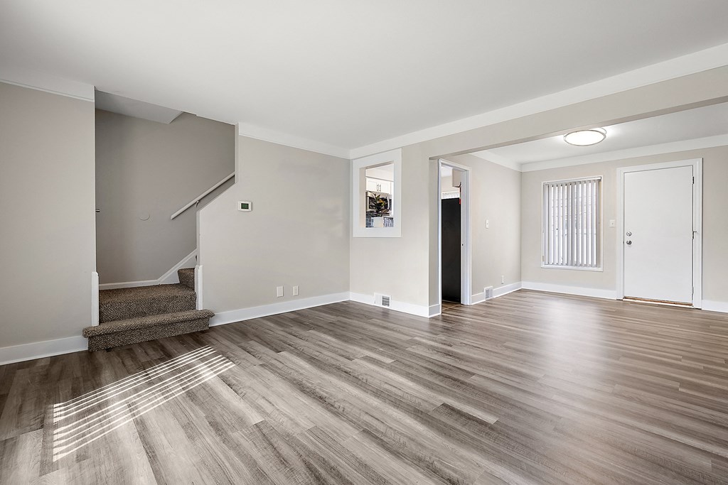 a living room with hardwood floors and grey walls