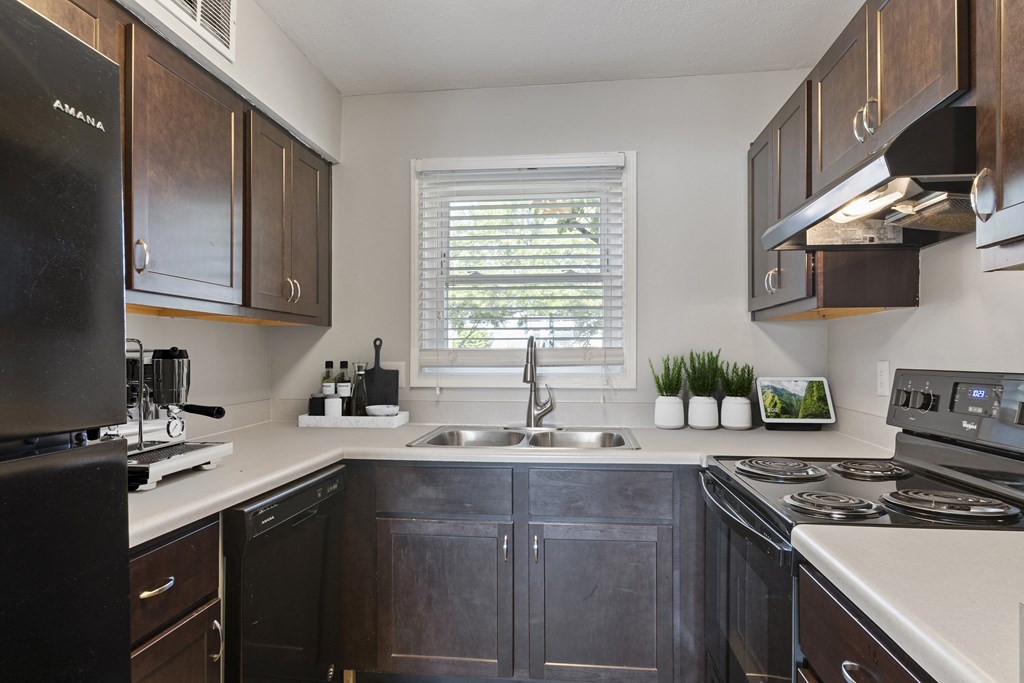 a kitchen with dark cabinets and white countertops