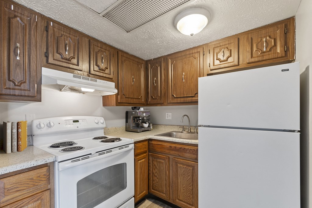 a kitchen with wood cabinets and white appliances