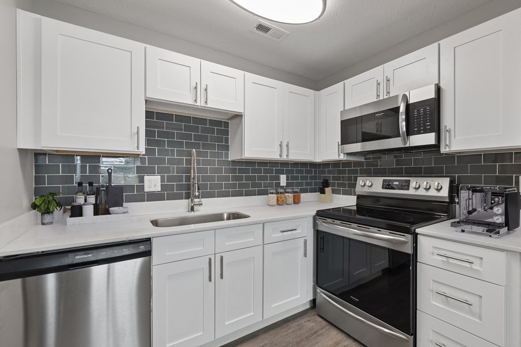 a kitchen with white cabinets and stainless steel appliances