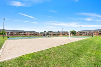 a sand volleyball court with a building in the background