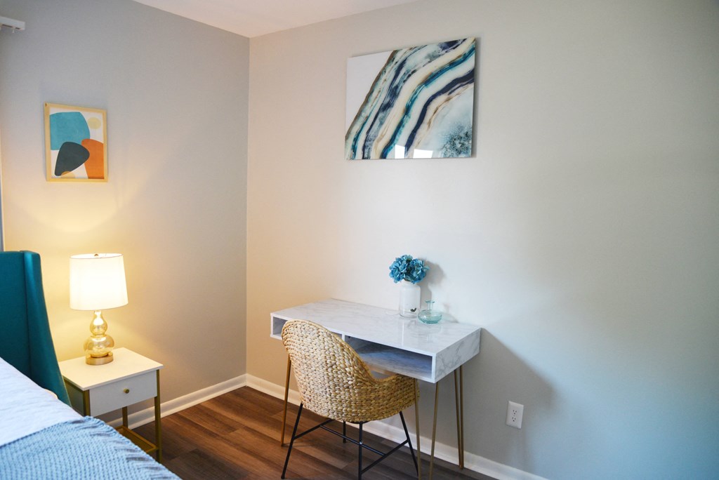 a desk with a chair and a lamp in a bedroom