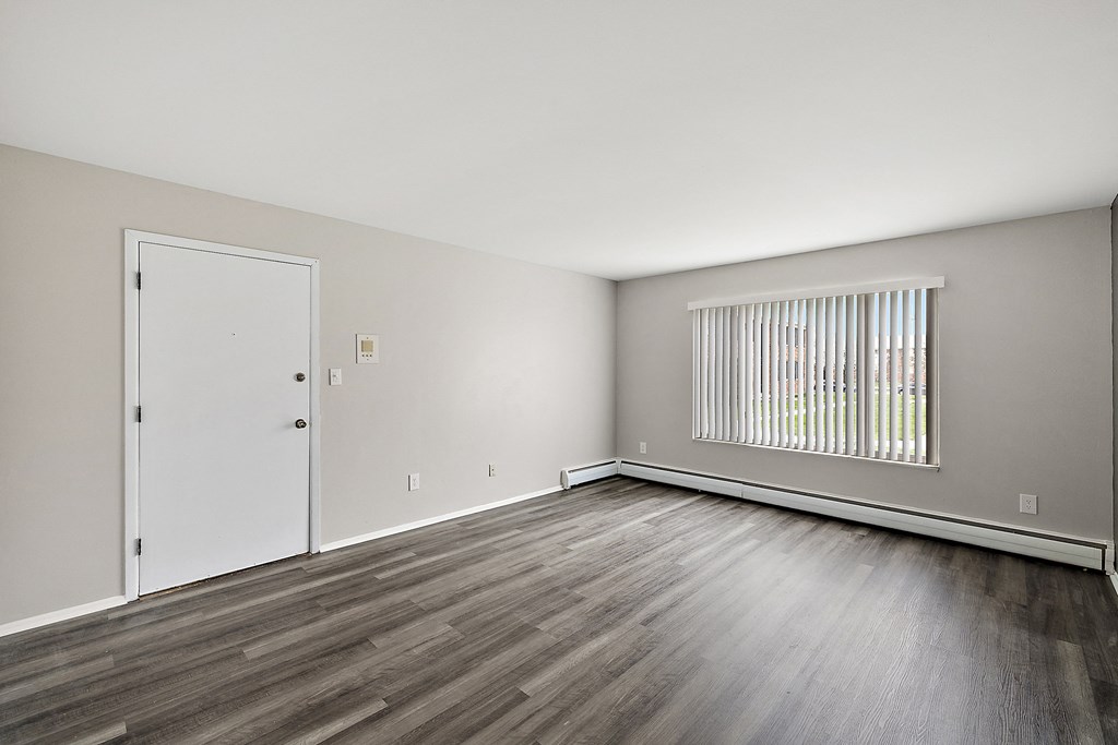 a bedroom with hardwood floors and grey walls
