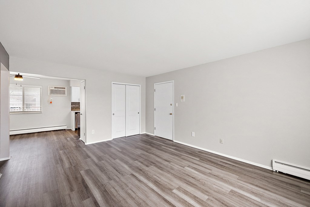 a bedroom with hardwood flooring and white walls