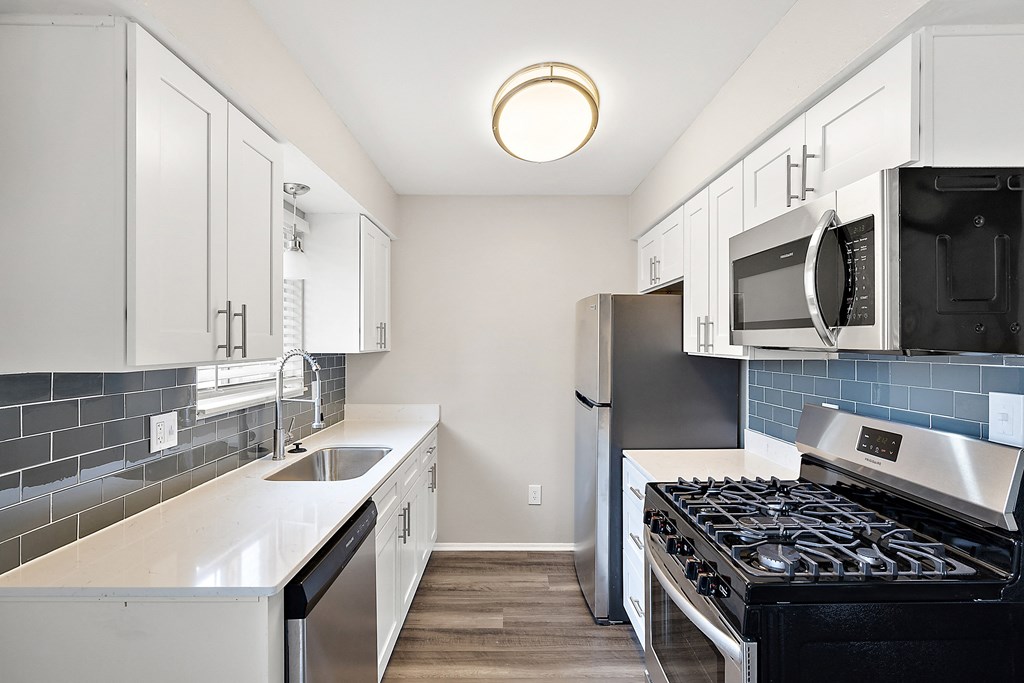 a kitchen with white cabinets and stainless steel appliances