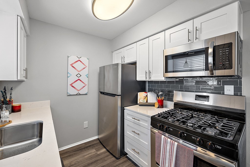 a kitchen with white cabinets and stainless steel appliances