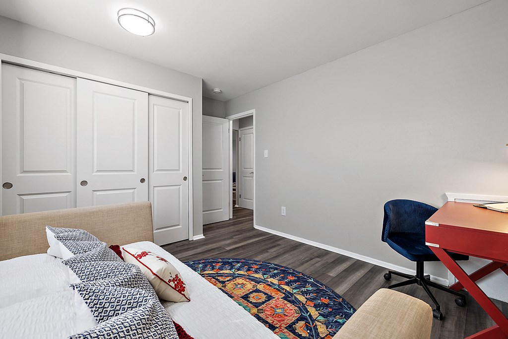 a bedroom with a bed and a desk with a chair