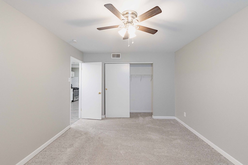 a bedroom with a ceiling fan and closet