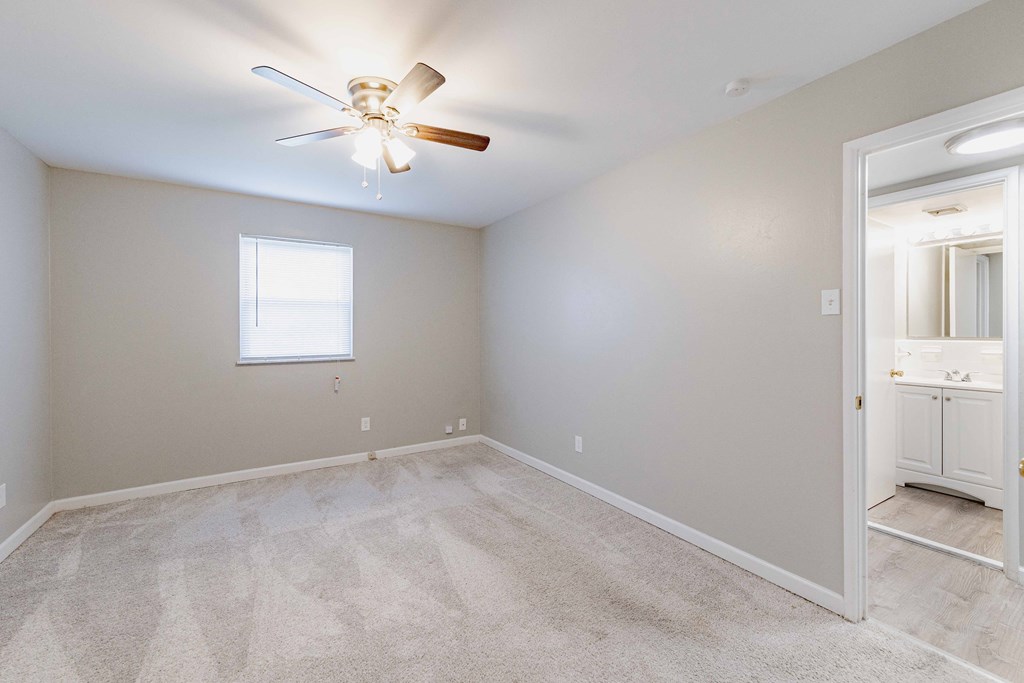 a bedroom with carpet and a ceiling fan