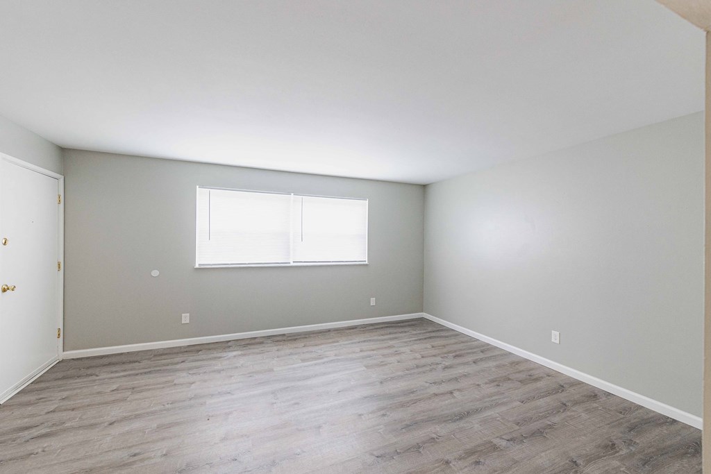 a bedroom with hardwood floors and grey walls