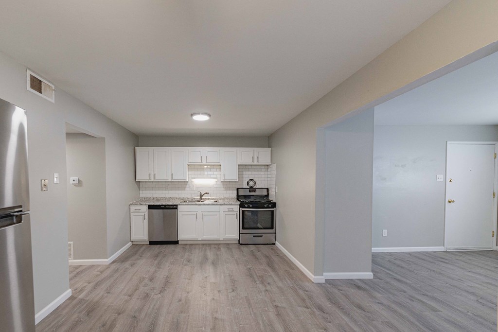 a kitchen with white cabinets and stainless steel appliances