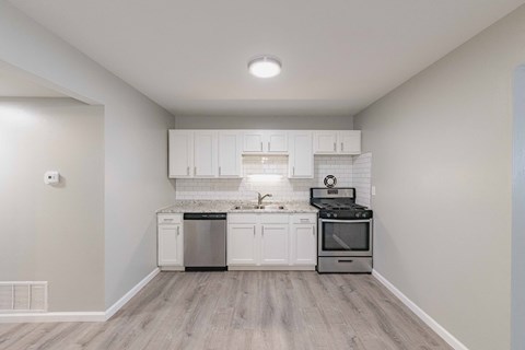 the kitchen of a new home with white cabinets and stainless steel appliances