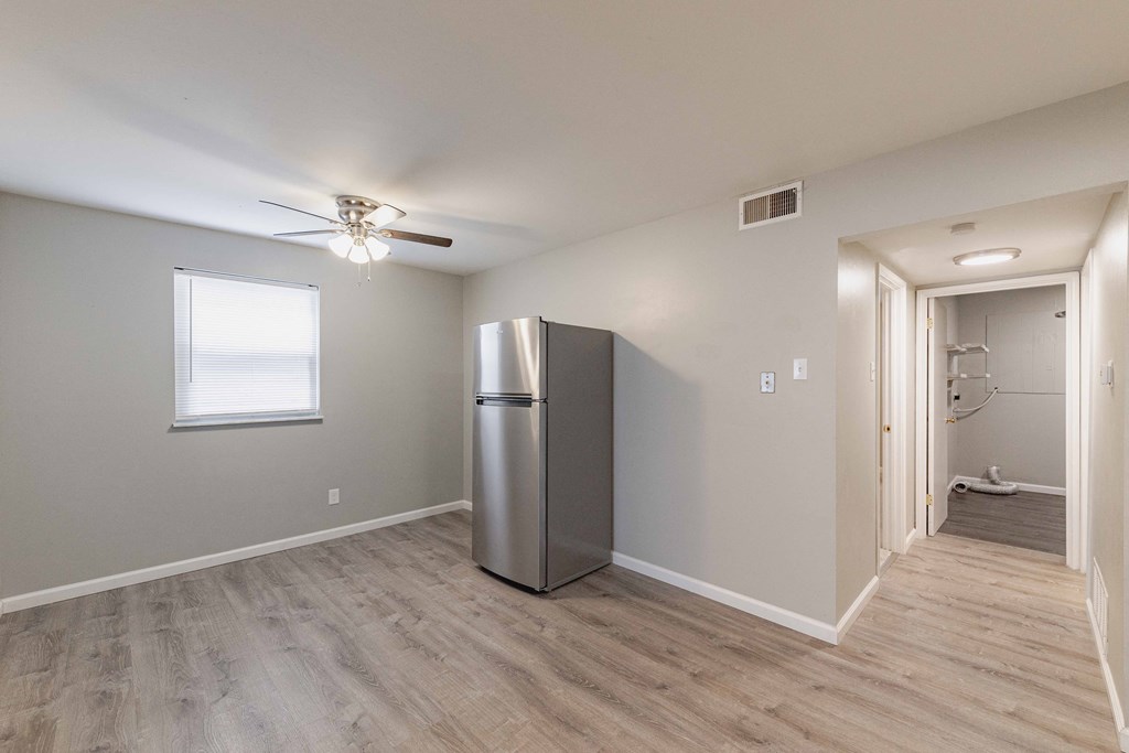 a kitchen with a refrigerator and a ceiling fan