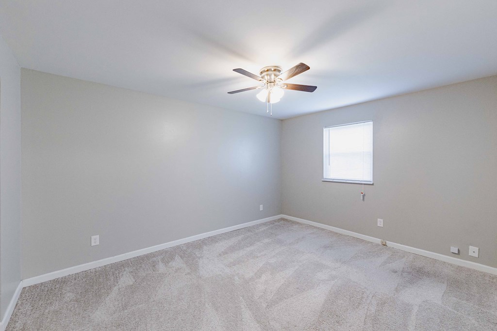 a bedroom with a ceiling fan and a window