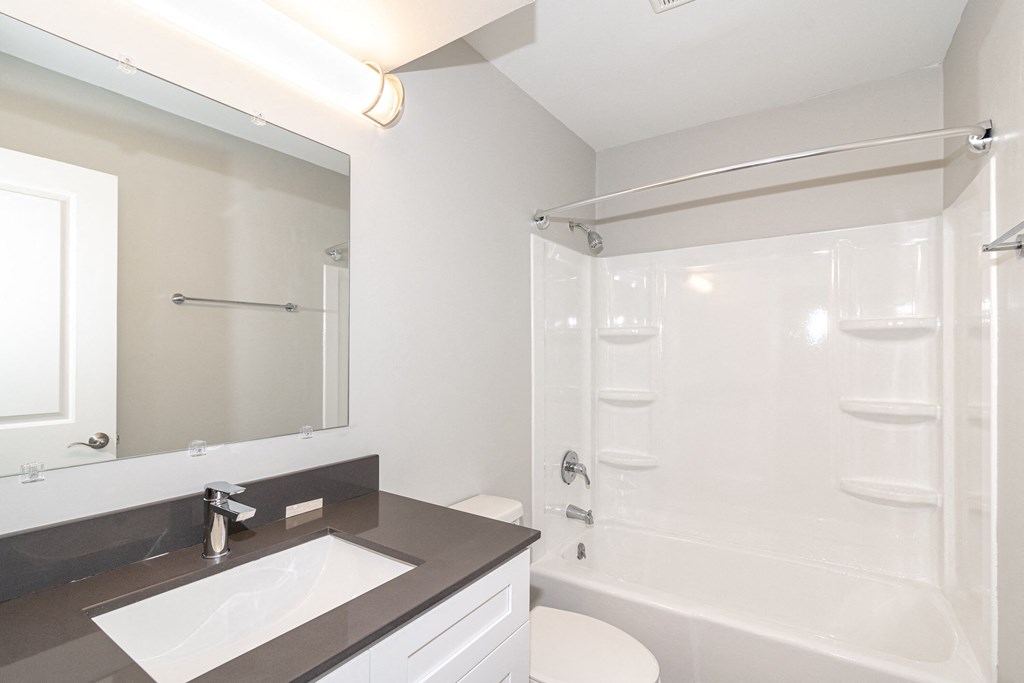 a bathroom with a shower and a sink and a mirror