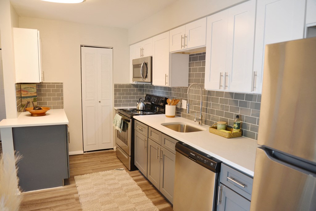 a kitchen with stainless steel appliances and white cabinets