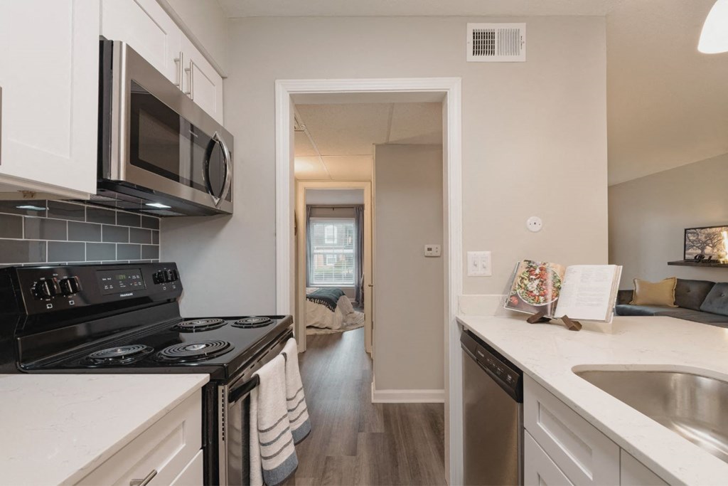 a kitchen with white cabinets and a black stove top oven