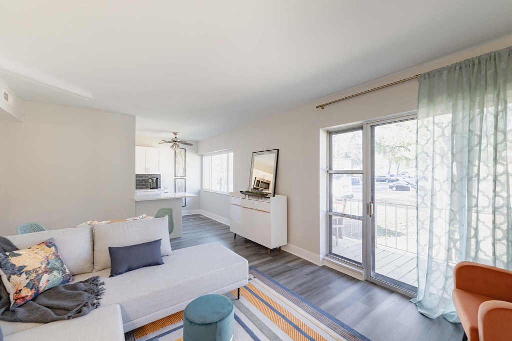the living room and kitchen of a house with large windows