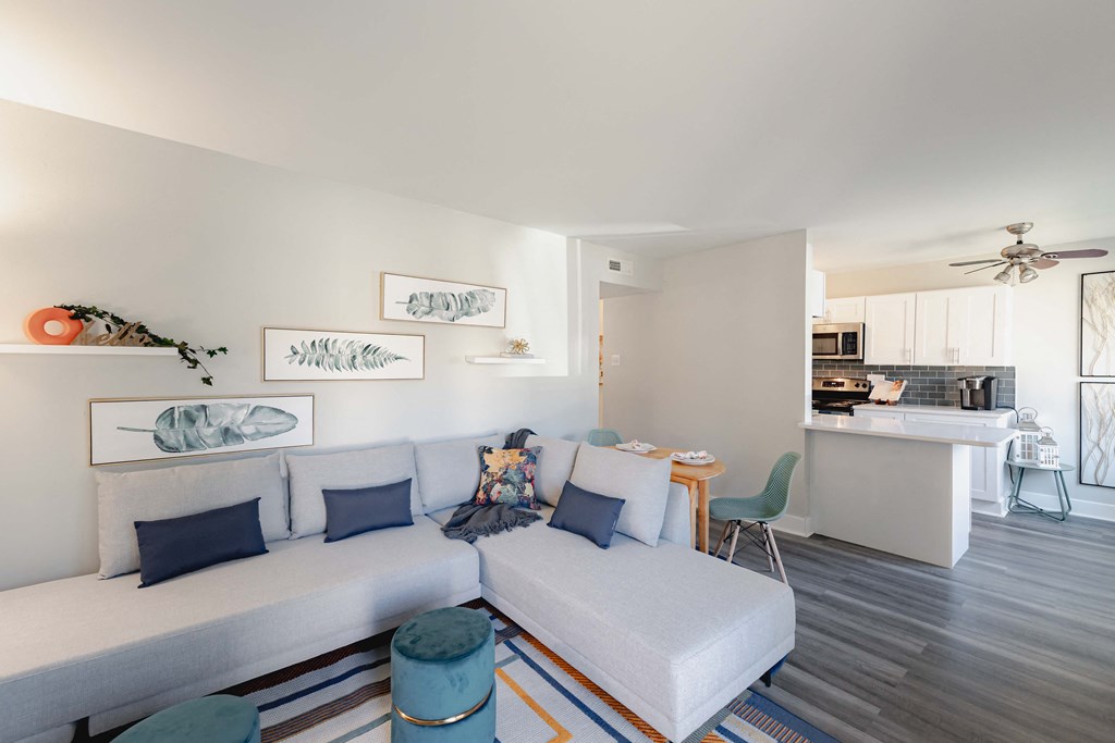 a living room with a couch and a table with a kitchen in the background