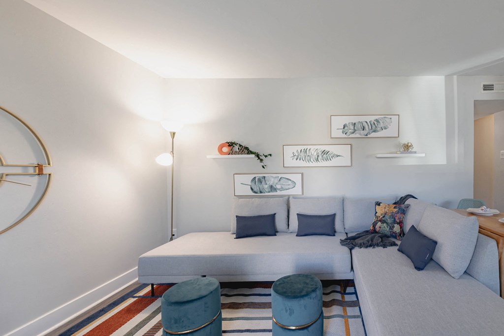 a living room with a white couch and a striped rug