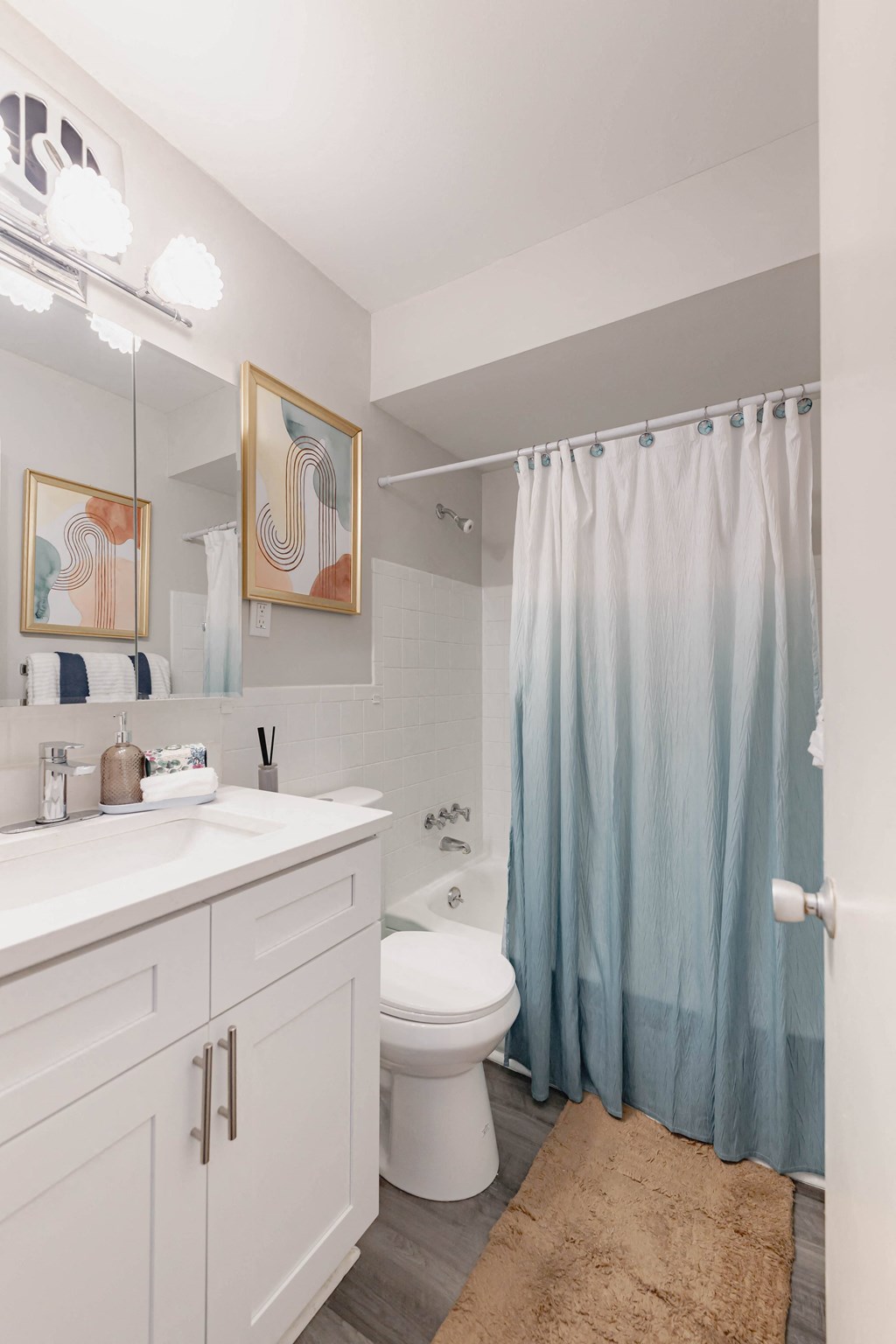 a white bathroom with a blue shower curtain and a toilet