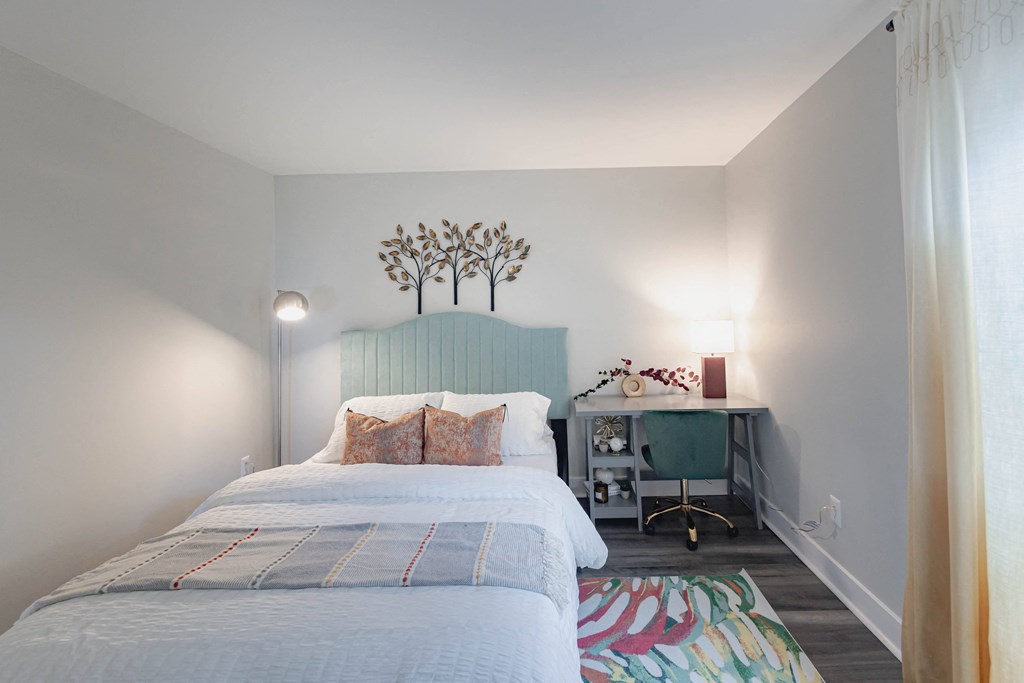 a bedroom with a bed and a desk with a chair