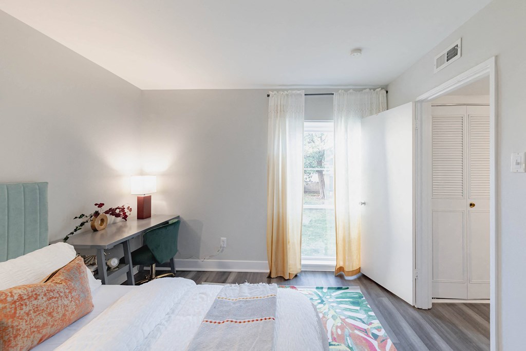a bedroom with a bed and a desk and sliding glass doors