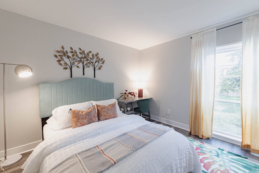 a bedroom with a bed and a rainbow painted wall