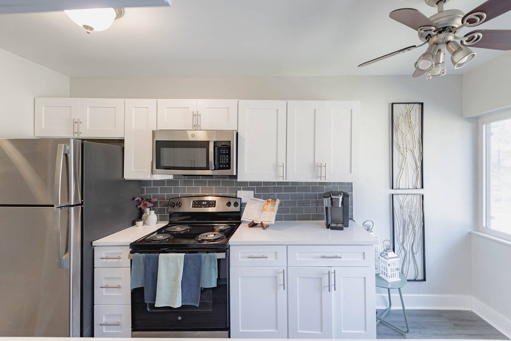 a kitchen with white cabinets and stainless steel appliances